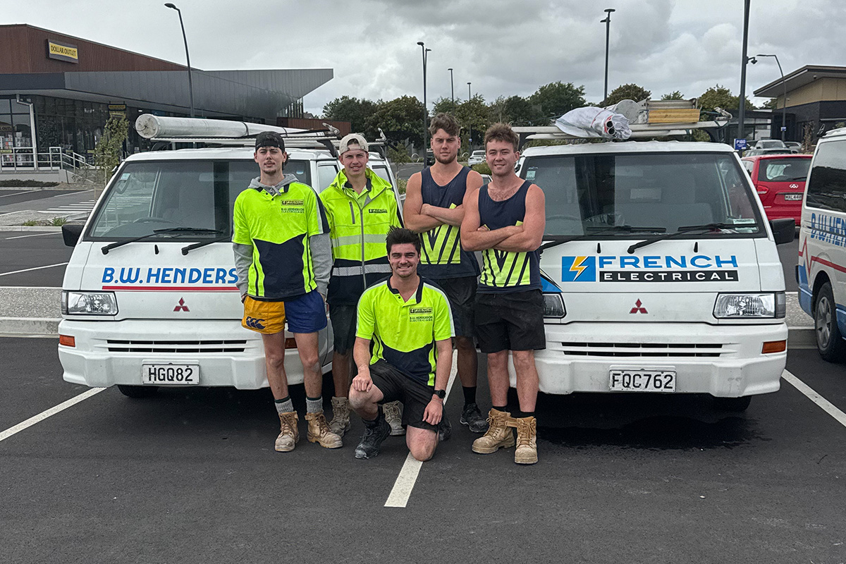 Electricians standing in front of BW Henderson and French Electrical vans