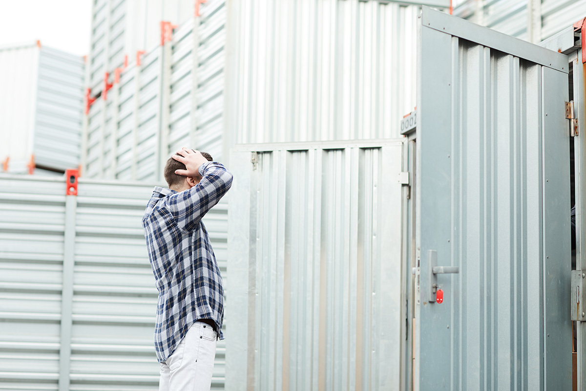 stressed man looking into open shipping container